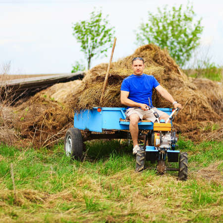 The man carries hay on a cart.の写真素材