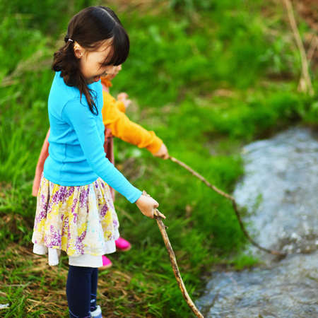The children happy outdoors sitting on river.の写真素材