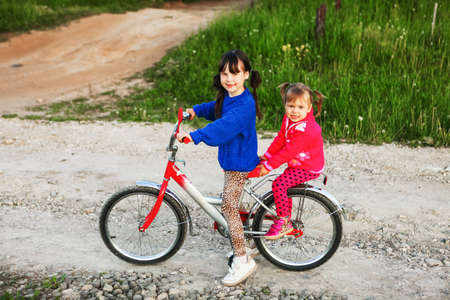 Little girl riding her bike through the village.の写真素材