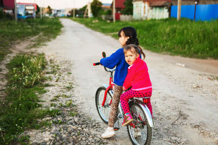 Little girl riding her bike through the village.の写真素材