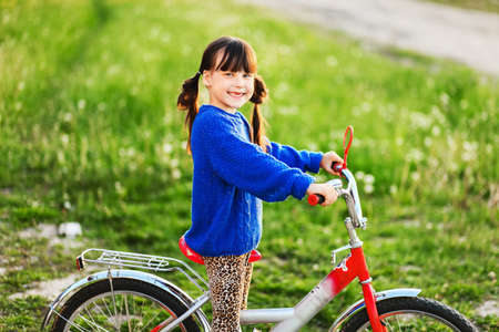 Little girl riding her bike through the village.の写真素材