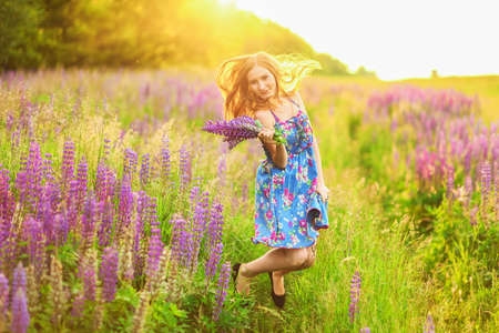 Beautiful young girl in the colours of the lupins.の写真素材