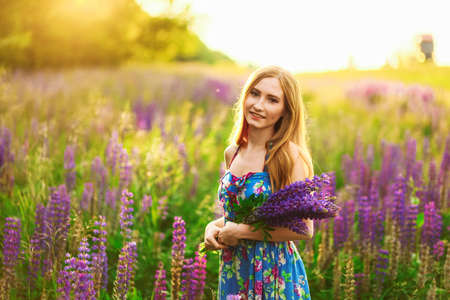 Beautiful young girl in the colours of the lupins.の写真素材