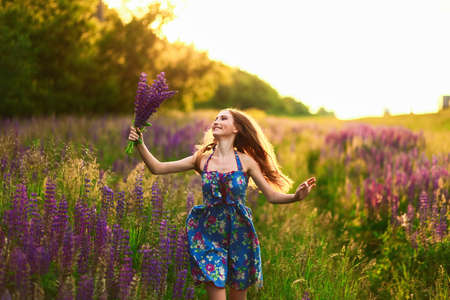 Beautiful young girl in the colours of the lupins.の写真素材