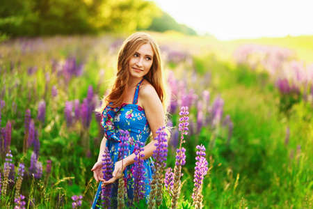 Beautiful young girl in the colours of the lupins.の写真素材