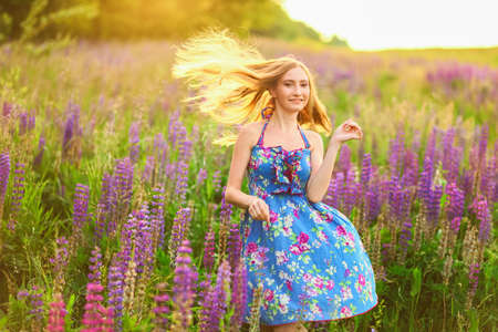 Beautiful young girl in the colours of the lupins.の写真素材