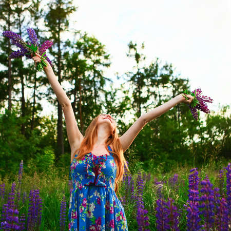 Beautiful young girl in the colours of the lupins.の写真素材