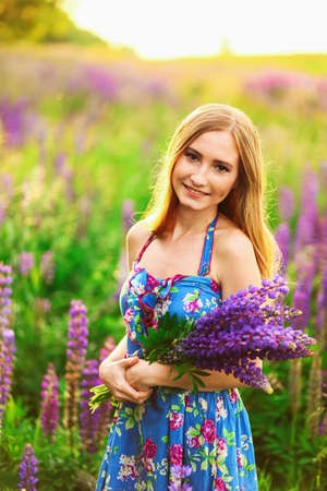 Beautiful young girl in the colours of the lupins.の写真素材