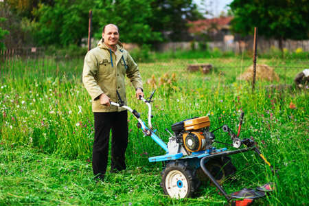 A man mowing the grass in the garden.の写真素材