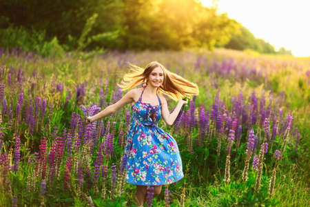 Beautiful young girl in the colours of the lupins.の写真素材