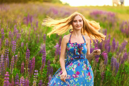 Beautiful young girl in the colours of the lupins.の写真素材