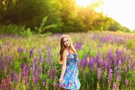 Beautiful young girl in the colours of the lupins.の写真素材