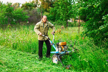 A man mowing the grass in the garden.の写真素材