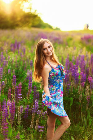Beautiful young girl in the colours of the lupins.の写真素材