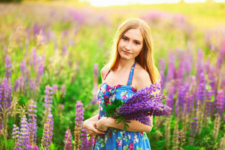 Beautiful young girl in the colours of the lupins.の写真素材