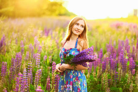 Beautiful young girl in the colours of the lupins.の写真素材