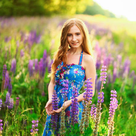Beautiful young girl in the colours of the lupins.の写真素材
