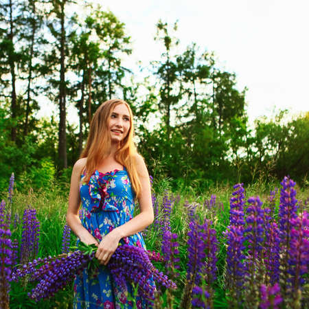 Beautiful young girl in the colours of the lupins.の写真素材