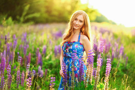 Beautiful young girl in the colours of the lupins.の写真素材
