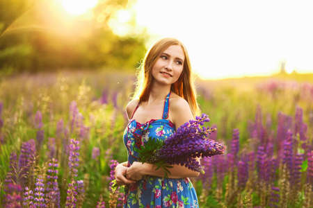 Beautiful young girl in the colours of the lupins.の写真素材