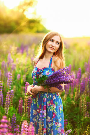 Beautiful young girl in the colours of the lupins.の写真素材