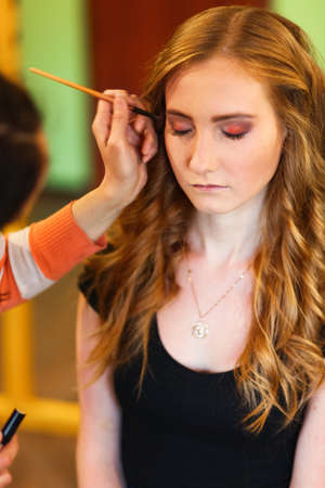 The young woman doing makeup a face.の写真素材