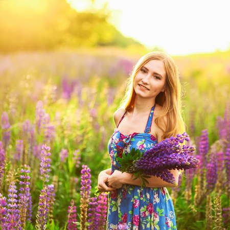 Beautiful young girl in the colours of the lupins.の写真素材