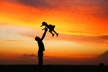 Silhouettes of people on bright evening sunset.の写真素材