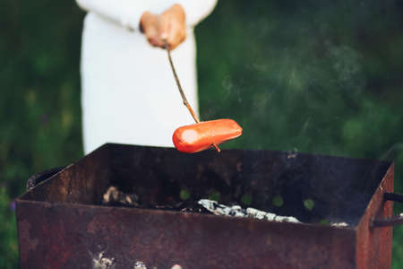 The Children preparing sausages on the coals.の写真素材
