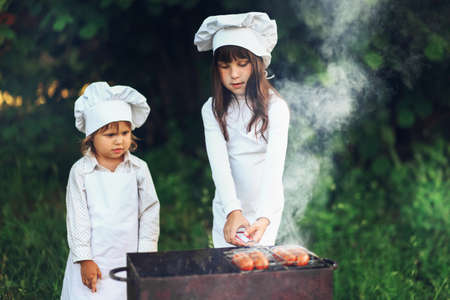 The Children preparing sausages on the coals.の写真素材