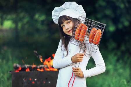The Children preparing sausages on the coals.の写真素材