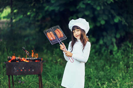 The Children preparing sausages on the coals.の写真素材