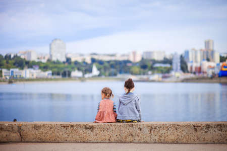 Little children sit on the city's background.の写真素材
