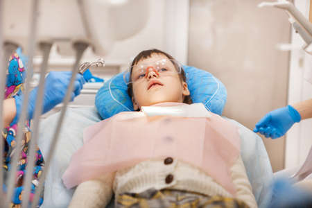 Little girl treats teeth at the dentist.の写真素材