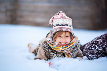 The Little girls playing with snow in winter.の写真素材