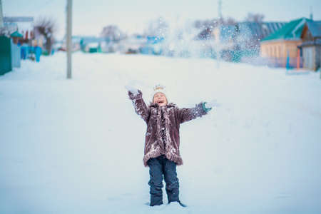 The girls playing with snow in winter.の写真素材