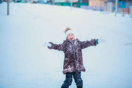 The girl playing with snow in outdoors winter.の写真素材