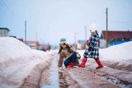 Little girls playing on the street in the village.の写真素材