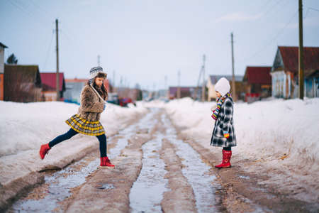 Little girls playing on the street in the village.の写真素材