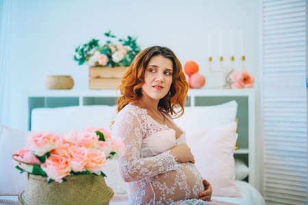 The Young pregnant woman in home interior.の写真素材