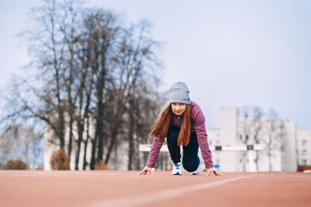 A young woman is engaged on a sports field.の写真素材