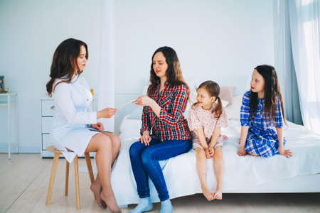 Little girls trust a young woman doctor.の写真素材