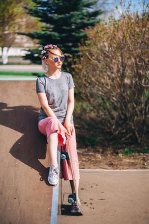 The Young woman portrait with a skateboard.の写真素材