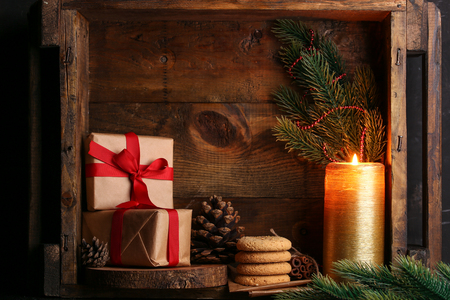 Christmas presents with cookies and candle light on wooden backgroundの写真素材