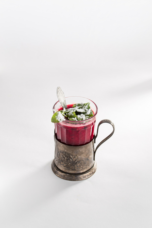 Winter berry tea with cranberries, mint, lemon, honey in a metal retro cup on white background. Vertical, closeup viewの写真素材