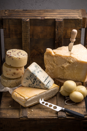 Various types of italian cheese on dark wooden tableの写真素材