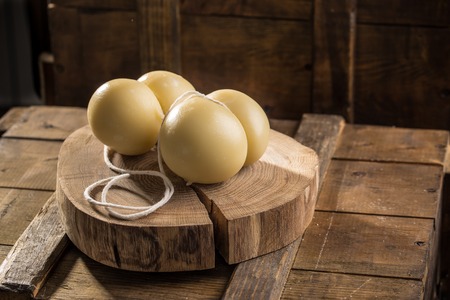 Gourmet italian cheese scamorza on wooden board on dark background. Studio shotの写真素材