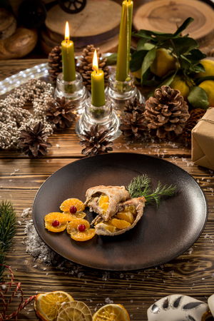 Roast Christmas duck with orange on wooden table on decorated christmas backgroundの写真素材