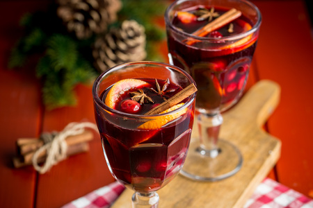 Christmas composition with spicy mulled wine and pine cones on red backgroundの写真素材