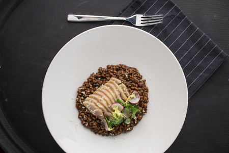 risotto with white fish fillet on black background. Studio shotの写真素材